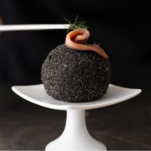 Arancino al nero di seppia con baccalà mantecato e acciughe del Cantabrico