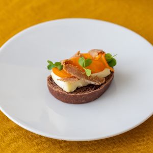 Crostone al cacao, brie, lamelle di bottarga e albicocca caramellata